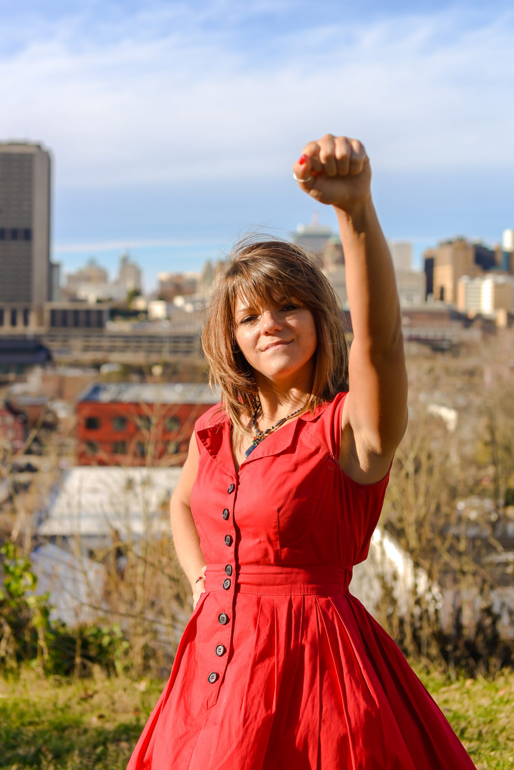 victorious, confident, fit, athletic, happy woman in red dress with city background, values are greater than motivation